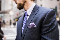 Businessman standing on city street — Stock Photo