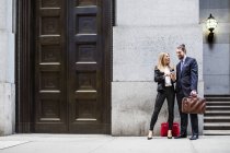 Geschäftsmann und Frau schauen aufs Smartphone — Stockfoto