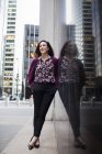 Бізнес-леді стоїть на тротуарі біля скляного вікна — стокове фото
