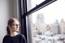 Business woman looking through window — стоковое фото