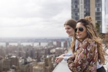 Друзі дивляться на місто на даху — стокове фото