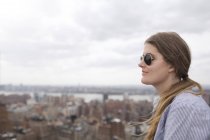 Frau betrachtet Stadt gegen den Himmel — Stockfoto