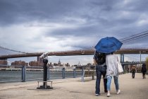 People walking on footpath by East River — Stock Photo