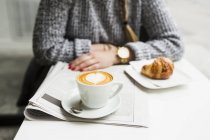 Femme avec café et journal — Photo de stock