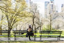 Frau sitzt auf Bank im Central Park — Stockfoto