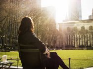 Mujer sentada en el banco en Bryant Park - foto de stock