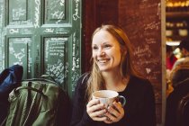 Усміхнена жінка тримає каву — стокове фото