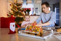 Father and daughter with gingerbread house — Stock Photo
