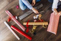 Man and woman wrapping gifts at home — Stock Photo