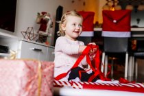 Cute girl playing with red ribbons — Stock Photo