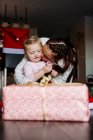 Mãe beijando filha durante o Natal — Fotografia de Stock