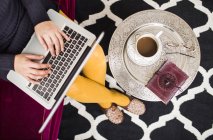 Mulher usando laptop enquanto toma café — Fotografia de Stock