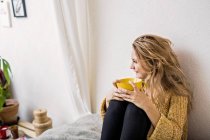 Femme souriante tenant tasse de café — Photo de stock