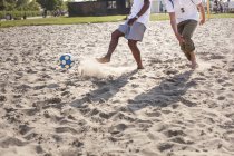 Amigos jugando al fútbol en la playa - foto de stock