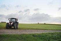 Tractor en campo herboso - foto de stock