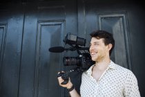 Homme portant caméra vidéo — Photo de stock