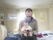 Father and daughter holding camera — Stock Photo