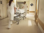 Медсестры толкают пациента в больницу — стоковое фото