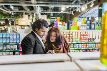 Couple shopping while standing in supermarket — Stock Photo