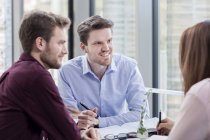 Businessmen looking at female colleague — Stock Photo