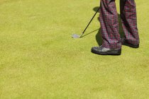 Homem com clube de golfe em campo — Fotografia de Stock