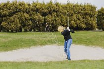 Жінка грає в гольф на полі — стокове фото