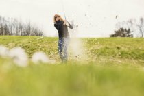 Женщина играет в гольф на поле для гольфа — стоковое фото