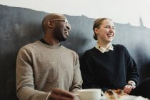 Cheerful friends sitting in coffee shop — Stock Photo