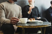 Amici seduti a tavola in caffetteria — Foto stock