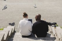 Деловые люди, использующие ноутбук на ступеньках — стоковое фото