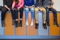 Escolares sentados en taquillas - foto de stock