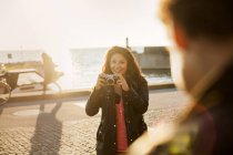 Young woman photographing friend — Stock Photo