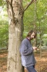 Людина спирається на дерево в лісі — стокове фото