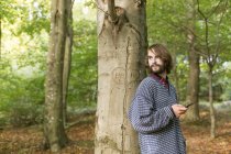 Mann lehnt im Wald an Baum — Stockfoto