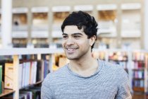 Щасливий молодий чоловік в бібліотеці — стокове фото