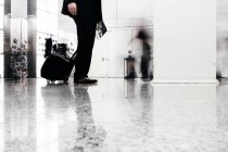 Businessman with luggage at office — Stock Photo