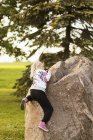 Girl climbing rock — Stock Photo
