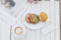 Breakfast with smart phone and newspaper — Stock Photo