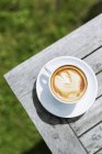 Cappuccino na mesa de madeira — Fotografia de Stock