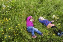 Girls sleeping on grassy field — Stock Photo