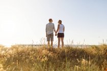 Young couple holding hands at beach — Stock Photo