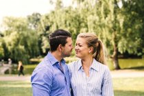 Smiling couple standing at park — Stock Photo