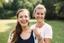 Smiling friends standing at park — Stock Photo