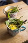 Zwei Tassen mit Blättern und Zitrone — Stockfoto