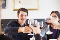 Amici brindare bicchieri da vino rossi — Foto stock
