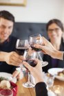 Amici brindare bicchieri da vino rossi — Foto stock