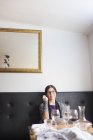 Mujer sentada en la mesa en el restaurante - foto de stock