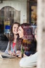 Счастливые друзья сидят в кафе — стоковое фото