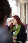 Young redhead woman sitting in cafe — Stock Photo