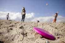 Flying disc on sandy beach — Stock Photo